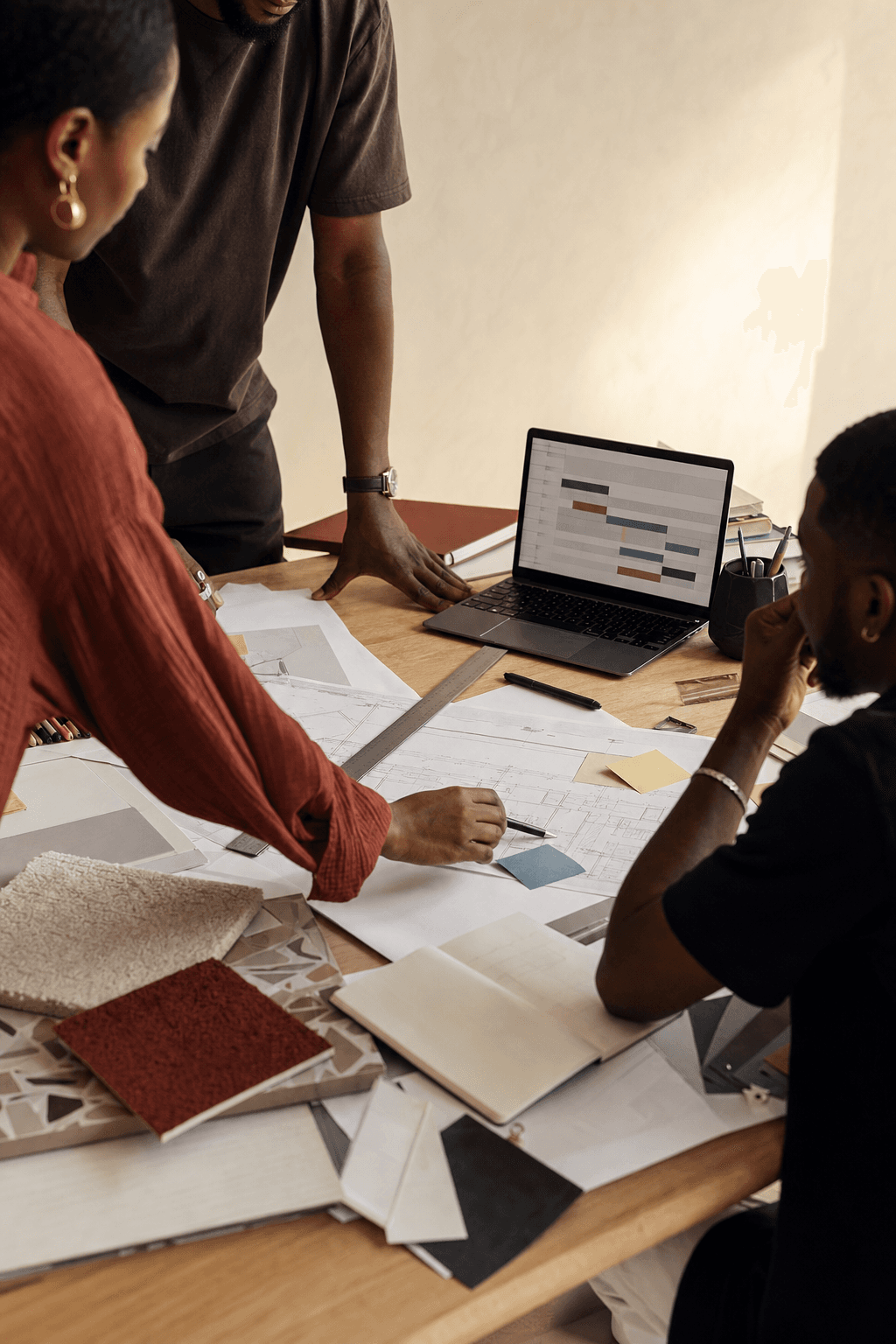 Colleagues reviewing a project schedule and documents around a table