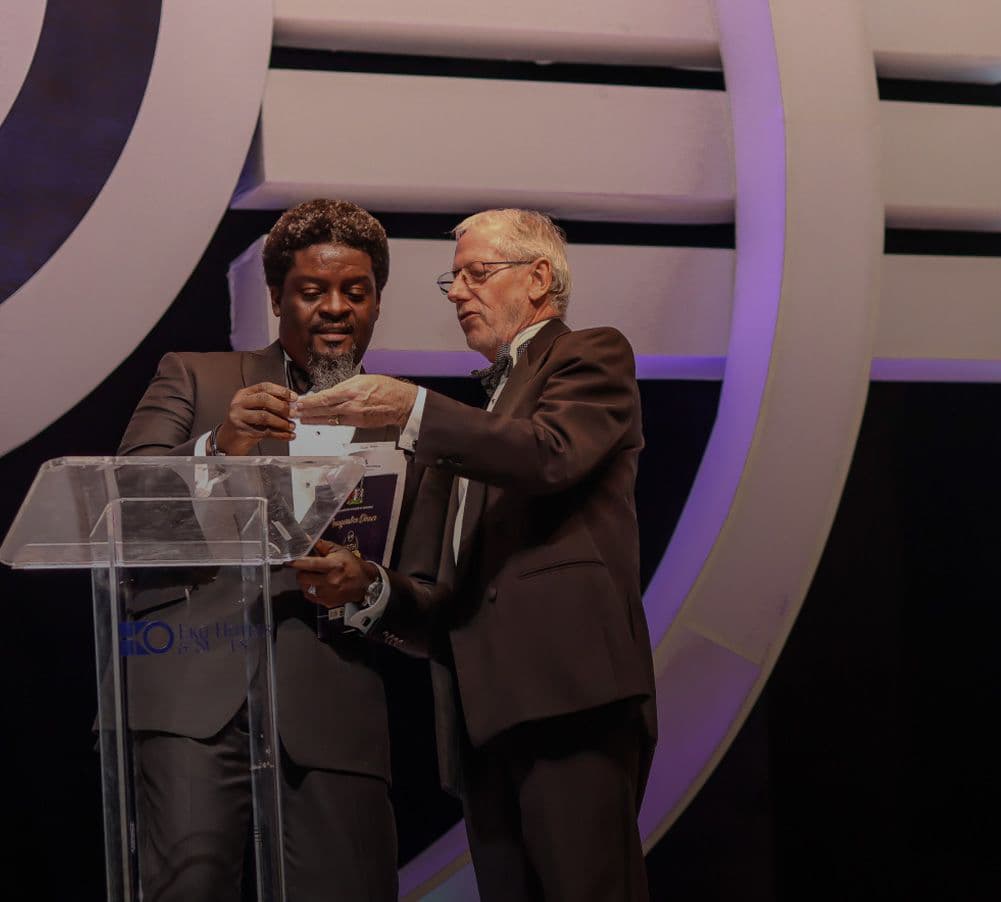 The Anchor presenting with a guest at a lectern