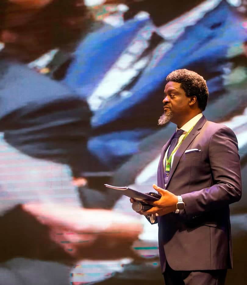 The Anchor speaking on stage at a live event